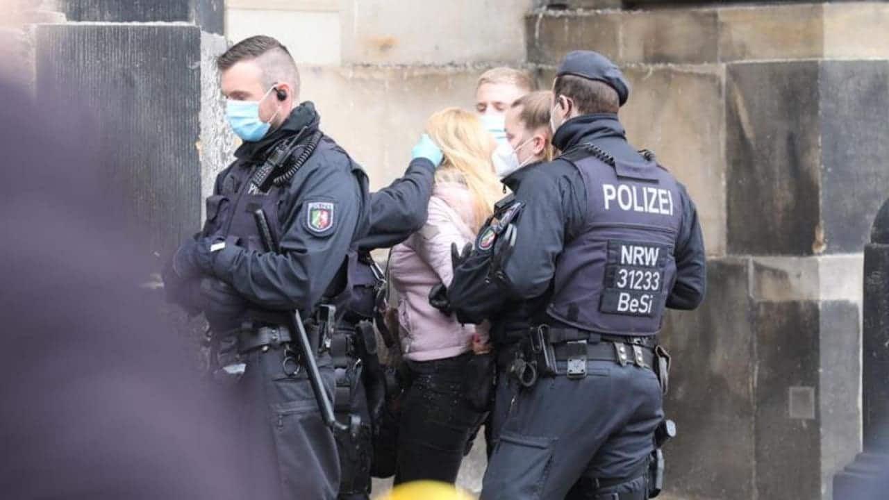 Кашляла на полицейских: в Дрездене женщине принудительно надели маску на лицо